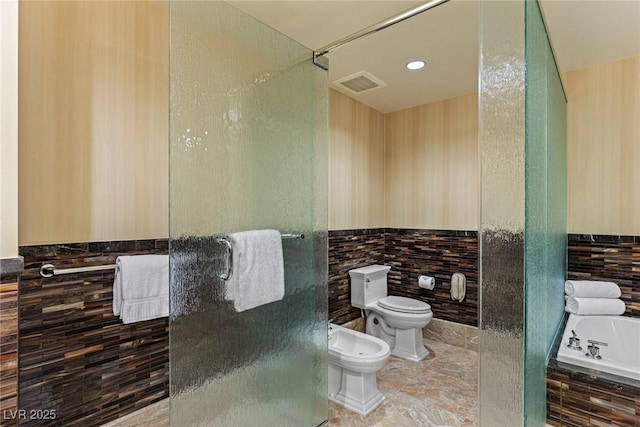 2000 Fashion Show Dr Unit 6109, Las Vegas, NV 89109 - full bath featuring tile walls, a bidet, a shower stall, tiled tub, and wainscoting
