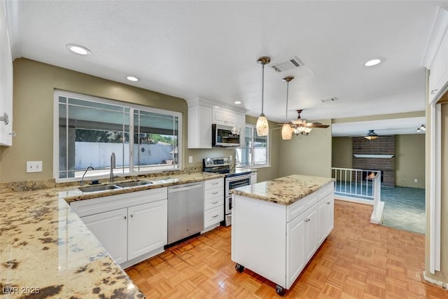 3746 E Harmon Ave, Las Vegas, NV 89121 - kitchen with stainless steel appliances, a ceiling fan, white cabinets, and recessed lighting
