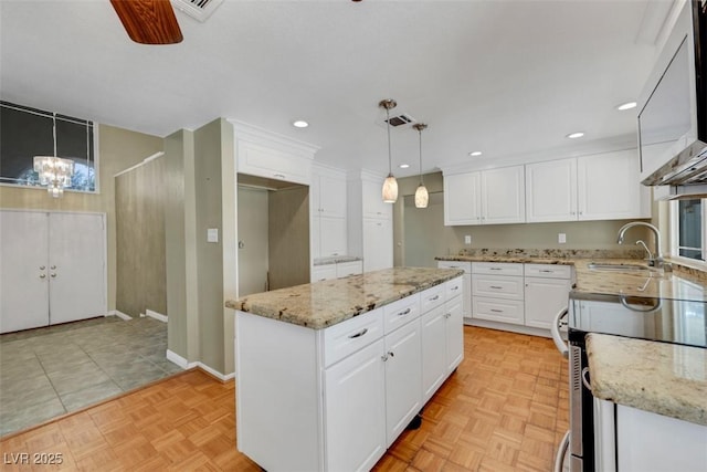 3746 E Harmon Ave, Las Vegas, NV 89121 - kitchen featuring stainless steel electric range, white cabinets, a center island, light stone countertops, and recessed lighting