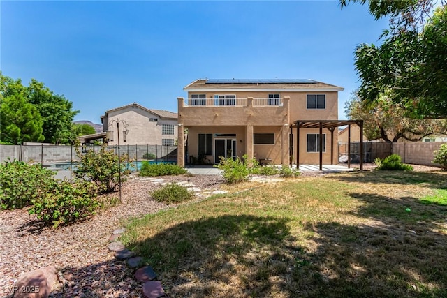 1798 Lakewood Dr, Henderson, NV 89012 - back of house with stucco siding, roof mounted solar panels, a fenced backyard, and a patio