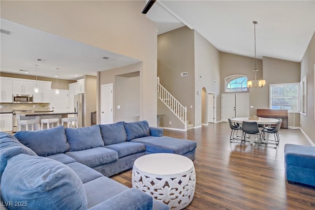 3420 Lockport St, Las Vegas, NV 89129 - living room with high vaulted ceiling, dark wood-type flooring, stairs, and a chandelier