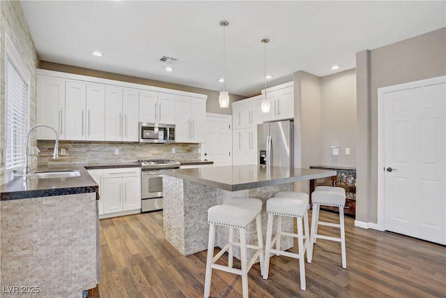 3420 Lockport St, Las Vegas, NV 89129 - kitchen featuring appliances with stainless steel finishes, wood finished floors, backsplash, white cabinets, and recessed lighting