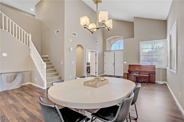 3420 Lockport St, Las Vegas, NV 89129 - dining area with stairs, wood finished floors, high vaulted ceiling, a chandelier, and arched walkways