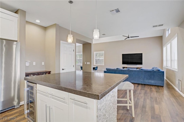 3420 Lockport St, Las Vegas, NV 89129 - kitchen featuring freestanding refrigerator, beverage cooler, dark countertops, a center island, and white cabinets