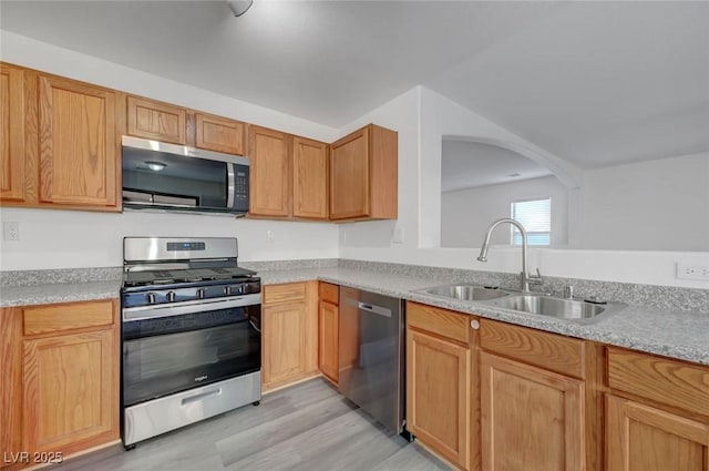 4751 Lone Grove Dr, Las Vegas, NV 89139 - kitchen with stainless steel appliances, light wood-type flooring, light countertops, and arched walkways