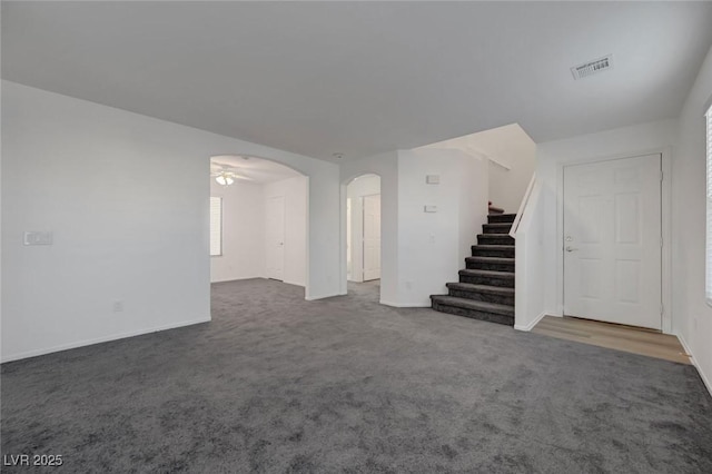 4751 Lone Grove Dr, Las Vegas, NV 89139 - unfurnished living room featuring carpet flooring, stairway, arched walkways, and ceiling fan