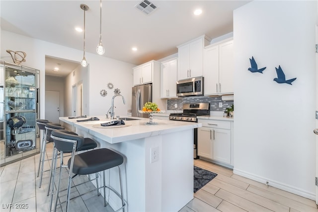 3782 Neblina Dr, Henderson, NV 89052 - kitchen with stainless steel appliances, tasteful backsplash, a breakfast bar, white cabinets, and recessed lighting
