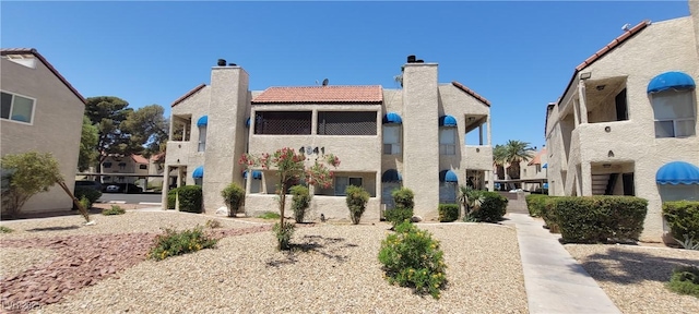 4941 Newport Cove Dr Unit B, Las Vegas, NV 89119 - rear view of house featuring a chimney, a tile roof, stucco siding, and a residential view