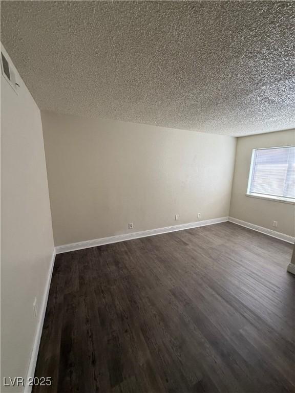 4941 Newport Cove Dr Unit B, Las Vegas, NV 89119 - empty room featuring a textured ceiling and dark wood finished floors