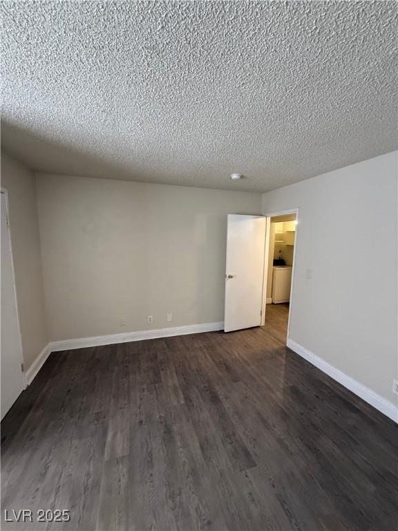 4941 Newport Cove Dr Unit B, Las Vegas, NV 89119 - unfurnished room featuring a textured ceiling and dark wood-style floors