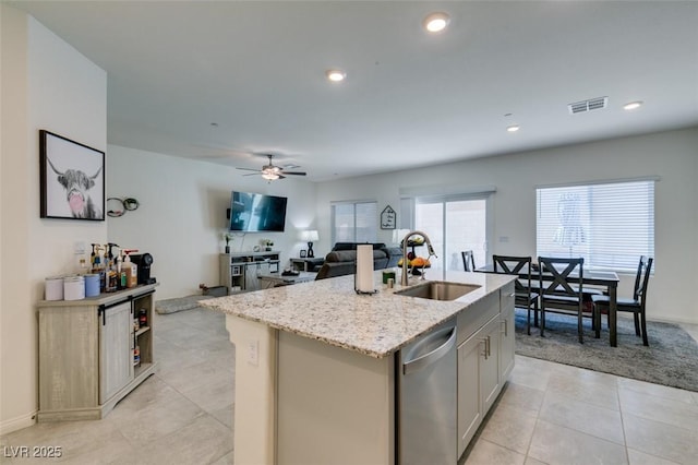10939 Cheshire Woods Ave, Las Vegas, NV 89166 - kitchen with stainless steel dishwasher, light stone countertops, a center island with sink, ceiling fan, and light tile patterned floors