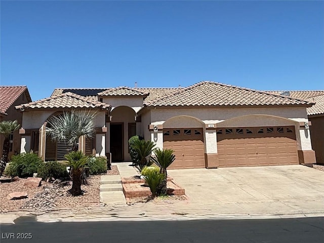 379 Marlin Cove Rd, Henderson, NV 89012 - mediterranean / spanish home featuring an attached garage, driveway, stucco siding, a tiled roof, and solar panels