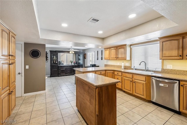 3930 Maranatha Cir, Las Vegas, NV 89103 - kitchen with stainless steel dishwasher, a raised ceiling, a peninsula, light tile patterned floors, and light countertops
