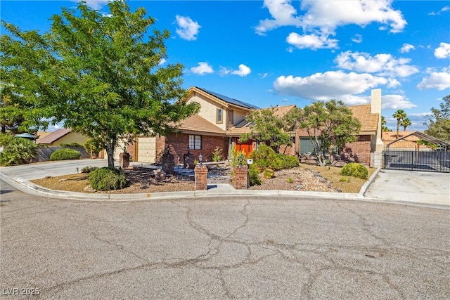 3930 Maranatha Cir, Las Vegas, NV 89103 - view of property hidden behind natural elements with driveway, solar panels, a gate, and stucco siding