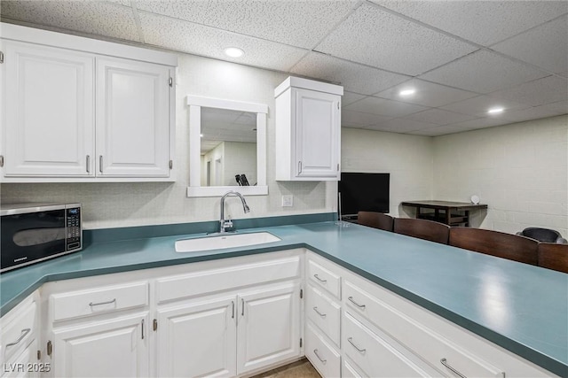 3930 Maranatha Cir, Las Vegas, NV 89103 - kitchen with black microwave, a drop ceiling, white cabinets, recessed lighting, and concrete block wall