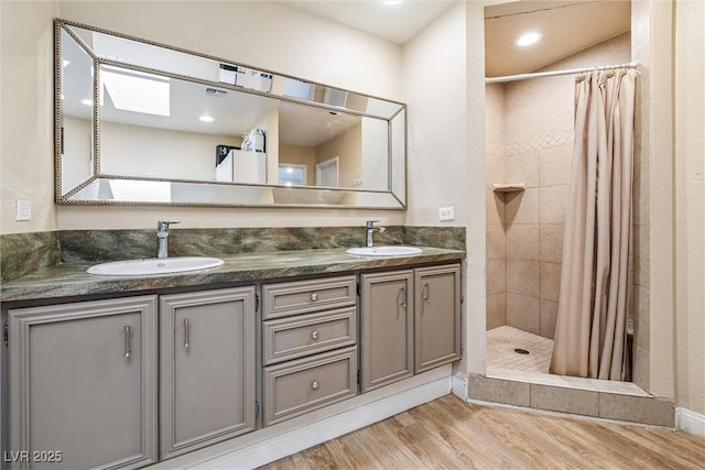 3930 Maranatha Cir, Las Vegas, NV 89103 - bathroom featuring a tile shower, double vanity, and wood finished floors