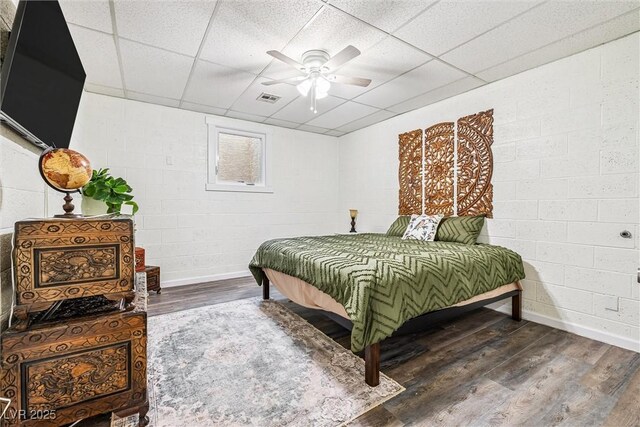 3930 Maranatha Cir, Las Vegas, NV 89103 - bedroom with wood finished floors, concrete block wall, a drop ceiling, and ceiling fan
