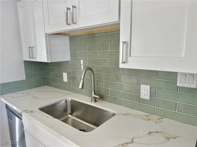 604 N Minnesota St, Las Vegas, NV 89107 - kitchen featuring white cabinets, decorative backsplash, light stone countertops, and dishwasher