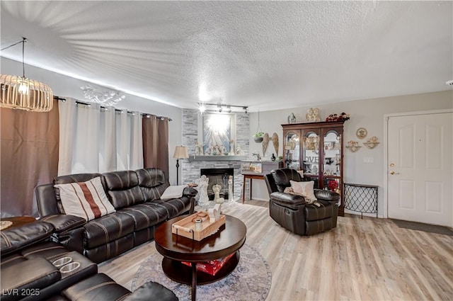 700 Capri Dr Unit 27B, Boulder City, NV 89005 - living area with a textured ceiling, wood finished floors, and a stone fireplace
