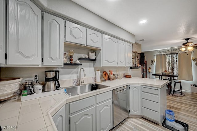 700 Capri Dr Unit 27B, Boulder City, NV 89005 - kitchen with stainless steel dishwasher, tile countertops, white cabinetry, a peninsula, and a ceiling fan