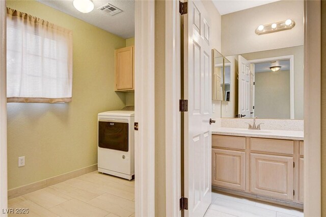2851 S Valley View Blvd Unit 1039, Las Vegas, NV 89102 - washroom with washer / clothes dryer, cabinet space, and light tile patterned flooring