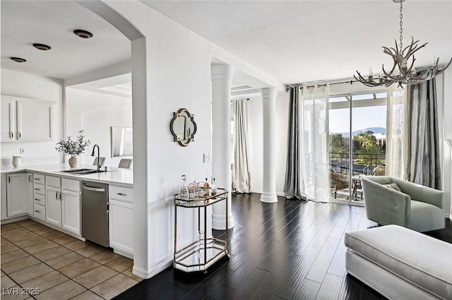9430 Laguna Niguel Dr Unit 203, Las Vegas, NV 89134 - kitchen with stainless steel dishwasher, arched walkways, light countertops, white cabinets, and a chandelier
