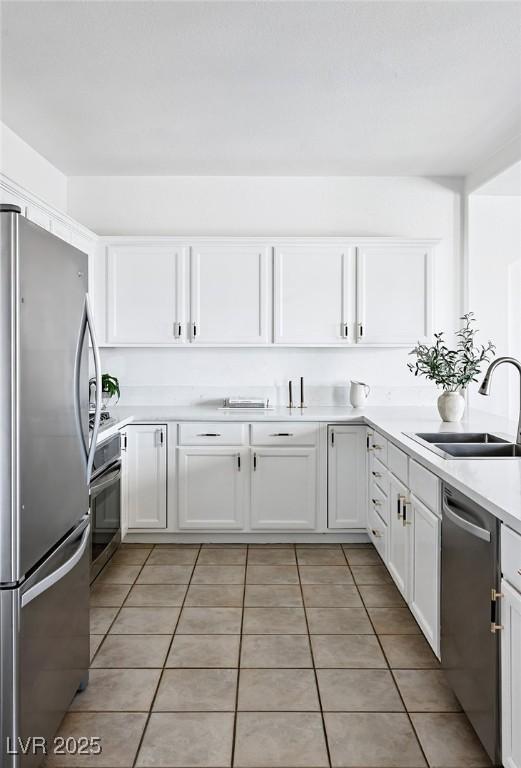 9430 Laguna Niguel Dr Unit 203, Las Vegas, NV 89134 - kitchen featuring appliances with stainless steel finishes, white cabinets, light tile patterned floors, and light countertops