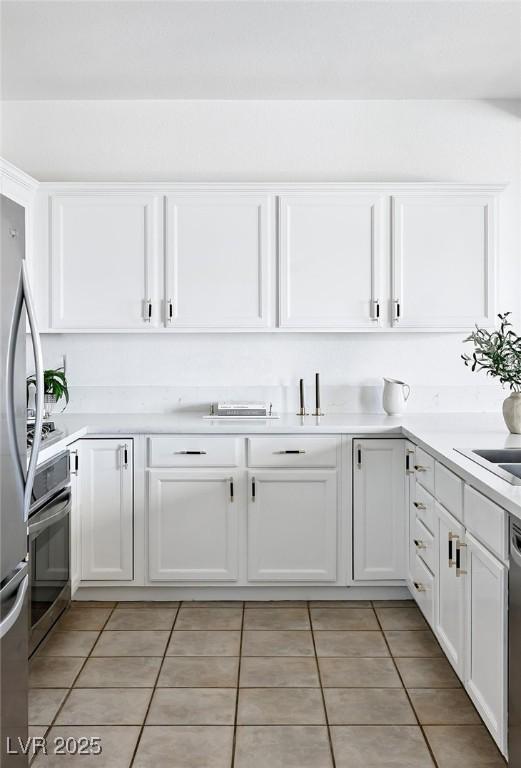 9430 Laguna Niguel Dr Unit 203, Las Vegas, NV 89134 - kitchen featuring white cabinets, stainless steel appliances, light tile patterned floors, and light countertops