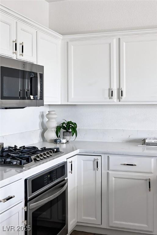 9430 Laguna Niguel Dr Unit 203, Las Vegas, NV 89134 - kitchen featuring stainless steel appliances, white cabinetry, and light countertops