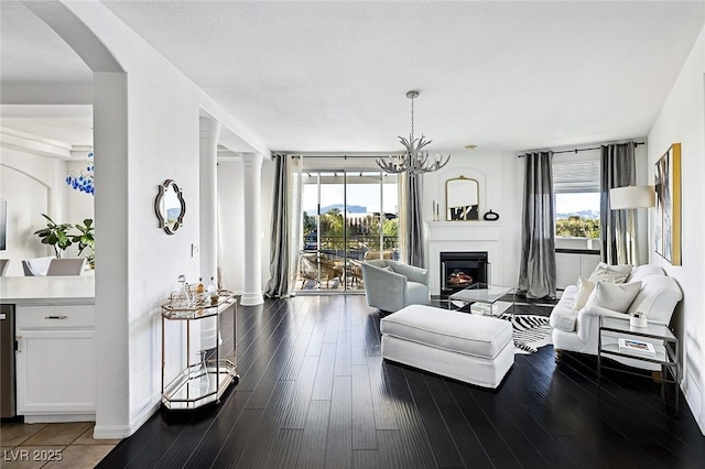 9430 Laguna Niguel Dr Unit 203, Las Vegas, NV 89134 - living room featuring a lit fireplace, wood finished floors, and arched walkways