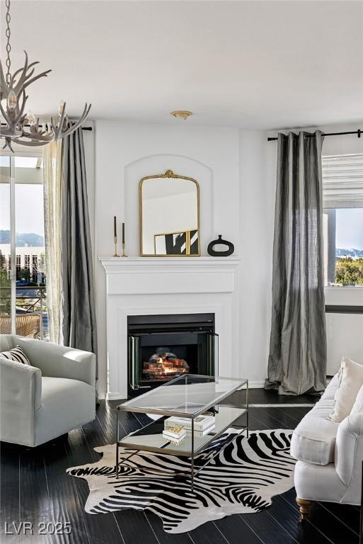9430 Laguna Niguel Dr Unit 203, Las Vegas, NV 89134 - living room featuring a chandelier, a glass covered fireplace, and wood finished floors