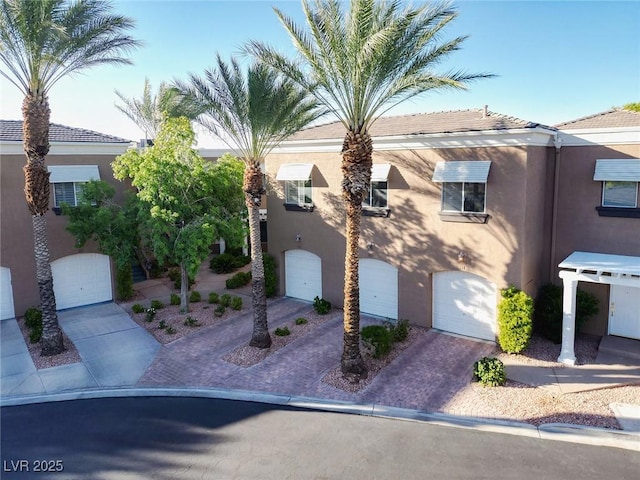 9430 Laguna Niguel Dr Unit 203, Las Vegas, NV 89134 - view of front of home with stucco siding, a garage, and decorative driveway