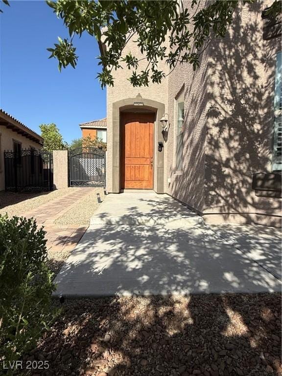 1146 Olivia Pkwy, Henderson, NV 89011 - view of exterior entry with a gate and stucco siding