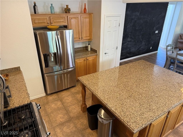 1146 Olivia Pkwy, Henderson, NV 89011 - kitchen with stainless steel fridge, a center island, light stone counters, and range