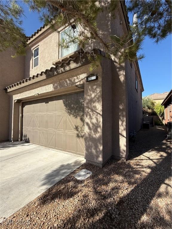1146 Olivia Pkwy, Henderson, NV 89011 - view of property exterior with a tiled roof, stucco siding, concrete driveway, and an attached garage