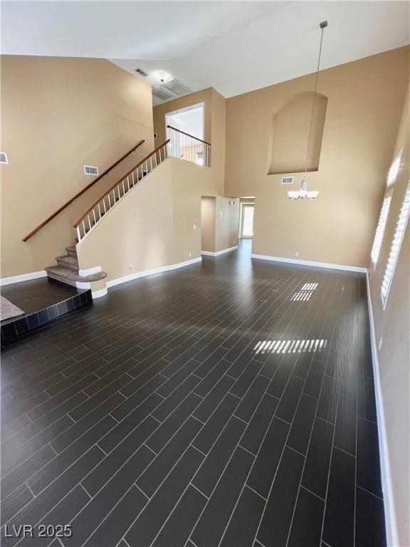 2140 Desert Peak Rd, Las Vegas, NV 89134 - unfurnished living room featuring high vaulted ceiling, stairway, and a chandelier