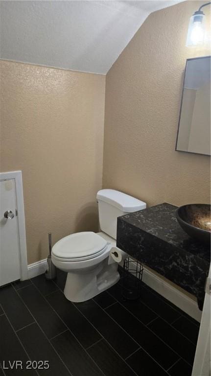 2140 Desert Peak Rd, Las Vegas, NV 89134 - bathroom with vaulted ceiling, a textured wall, tile patterned floors, and vanity