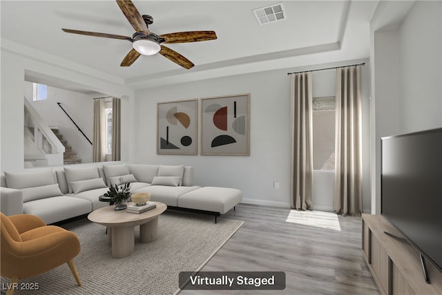 9784 Kodiak Island Ct, Las Vegas, NV 89141 - living area featuring ceiling fan, a raised ceiling, light wood-type flooring, and stairs