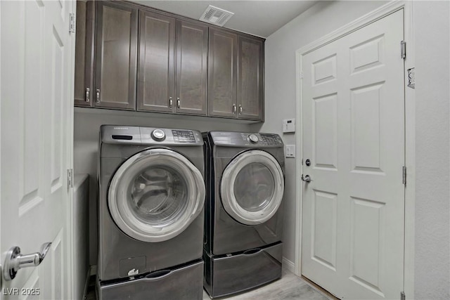 9784 Kodiak Island Ct, Las Vegas, NV 89141 - washroom with cabinet space, washing machine and clothes dryer, and light wood-style floors