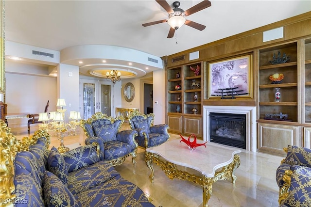 9101 Alta Dr Unit 301, Las Vegas, NV 89145 - living area featuring built in shelves, a glass covered fireplace, a ceiling fan, recessed lighting, and a chandelier