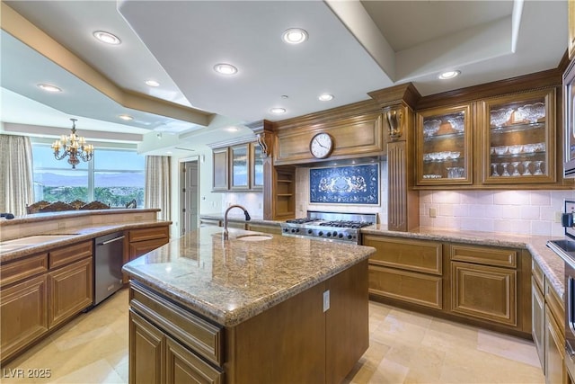 9101 Alta Dr Unit 301, Las Vegas, NV 89145 - kitchen with stainless steel appliances, tasteful backsplash, light stone countertops, a center island with sink, and recessed lighting