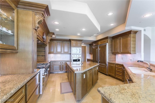 9101 Alta Dr Unit 301, Las Vegas, NV 89145 - kitchen with built in appliances, light stone counters, recessed lighting, backsplash, and an island with sink