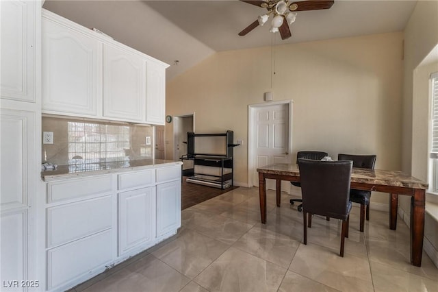 7720 W Agate Ave, Las Vegas, NV 89113 - kitchen featuring lofted ceiling, ceiling fan, white cabinets, tasteful backsplash, and light countertops