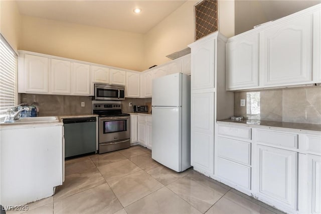7720 W Agate Ave, Las Vegas, NV 89113 - kitchen with appliances with stainless steel finishes, decorative backsplash, white cabinetry, recessed lighting, and a towering ceiling