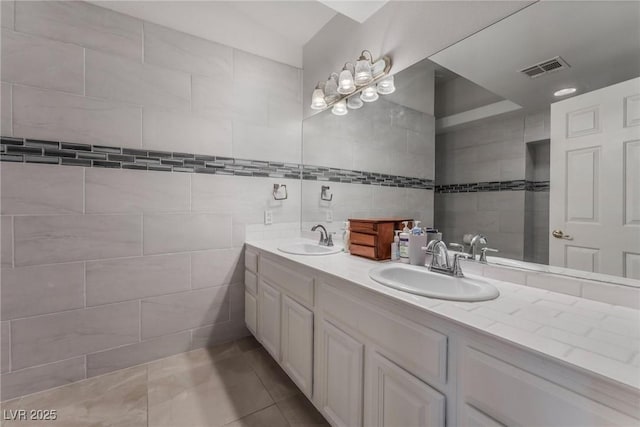 7720 W Agate Ave, Las Vegas, NV 89113 - full bath featuring tile walls, double vanity, a chandelier, and tile patterned floors