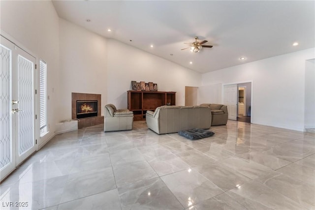 7720 W Agate Ave, Las Vegas, NV 89113 - living area featuring light marble finish floors, a ceiling fan, a tiled fireplace, high vaulted ceiling, and recessed lighting