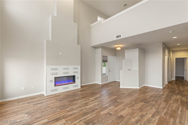 251 Big Horn Dr, Boulder City, NV 89005 - unfurnished living room featuring wood finished floors, a towering ceiling, and a fireplace