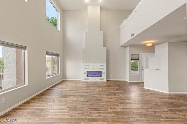 251 Big Horn Dr, Boulder City, NV 89005 - unfurnished living room with a towering ceiling, wood finished floors, and a fireplace