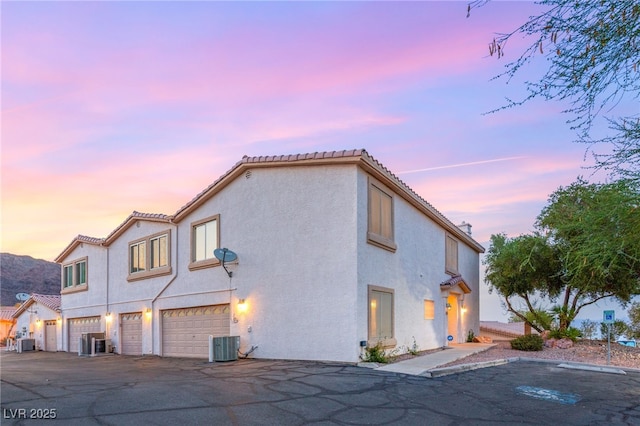 251 Big Horn Dr, Boulder City, NV 89005 - property exterior at dusk featuring a garage, stucco siding, driveway, and a tile roof
