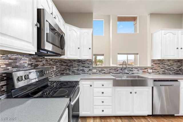 251 Big Horn Dr, Boulder City, NV 89005 - kitchen with stainless steel appliances, white cabinets, light countertops, and decorative backsplash